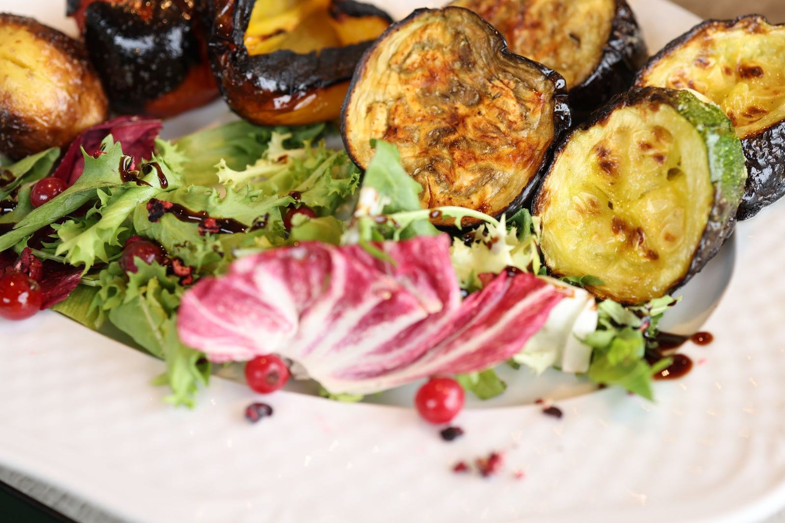 Assiette végétarienne d'aubergines et courgettes grillées sur salade de jeunes pousses et trévise